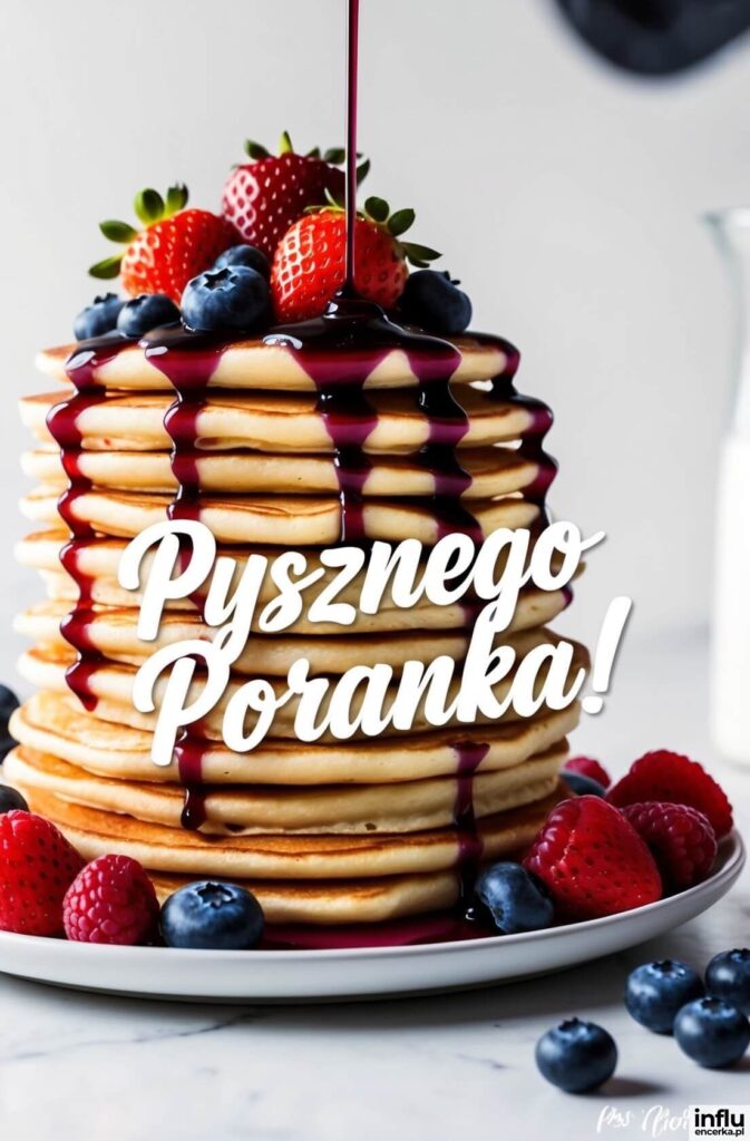 Wysoka wieża naleśników polanych ciemnym syropem jagodowym, udekorowanych truskawkami, malinami i borówkami, z napisem „Pysznego Poranka!”