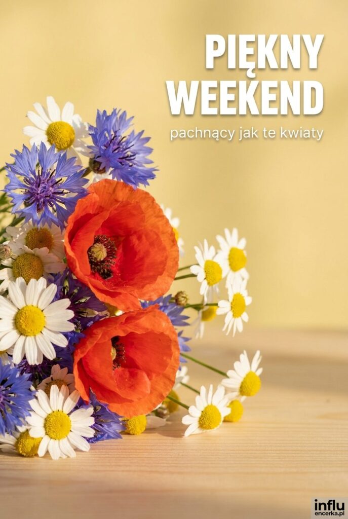 Bliski kadr polnych kwiatów na drewnianym stole z napisem „Piękny weekend" na rozmytym tle.