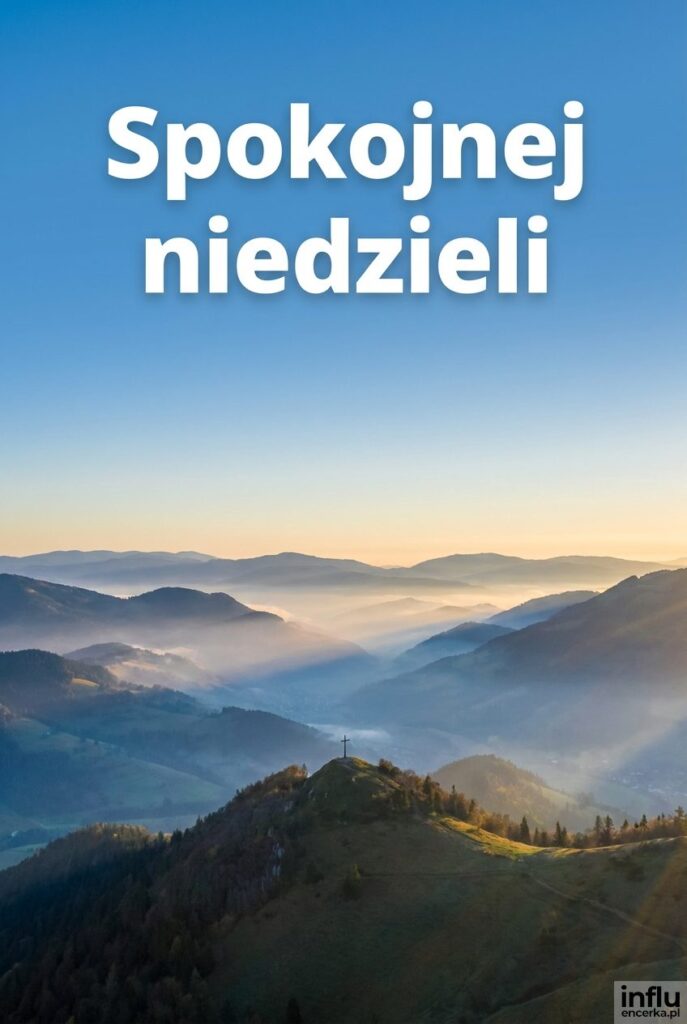 Panorama gór z krzyżem na szczycie o wschodzie słońca i napisem „Spokojnej niedzieli”.