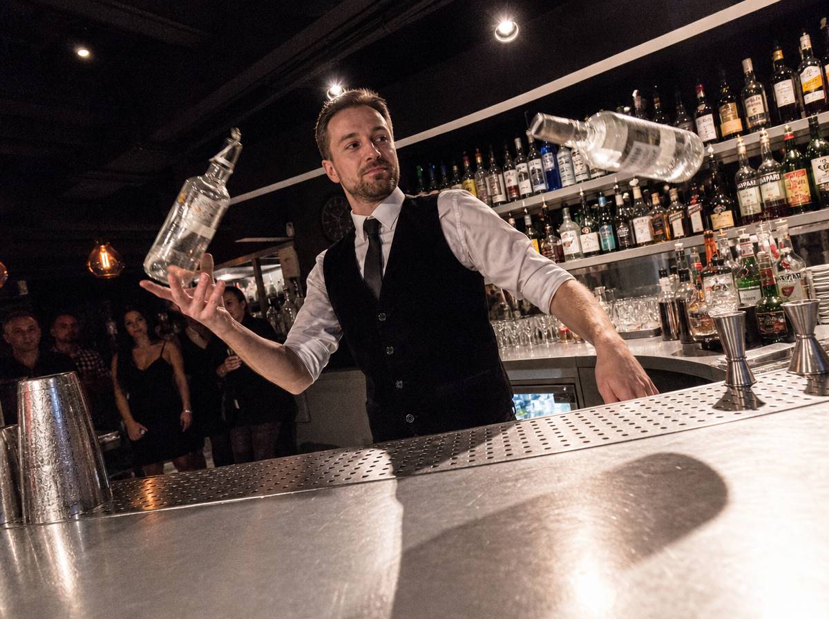 Pokazowy bar z barmanem żonglującym butelkami na weselu