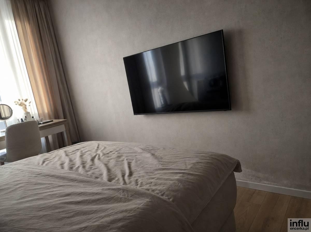 Fototapeta o betonowej fakturze jako tło dla telewizora w sypialni