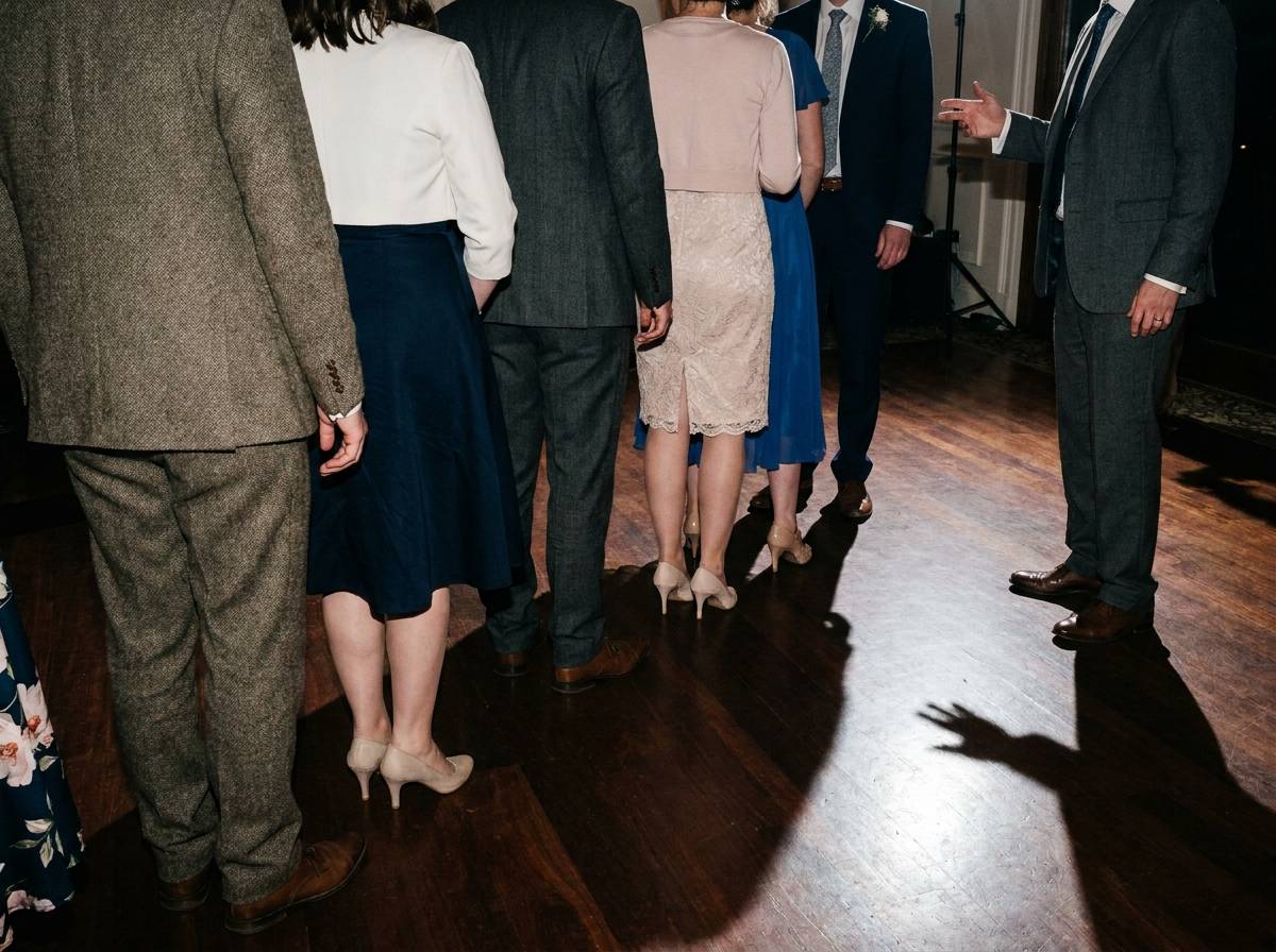 Goście uczący się wspólnego układu tanecznego jako niespodzianka dla pary młodej