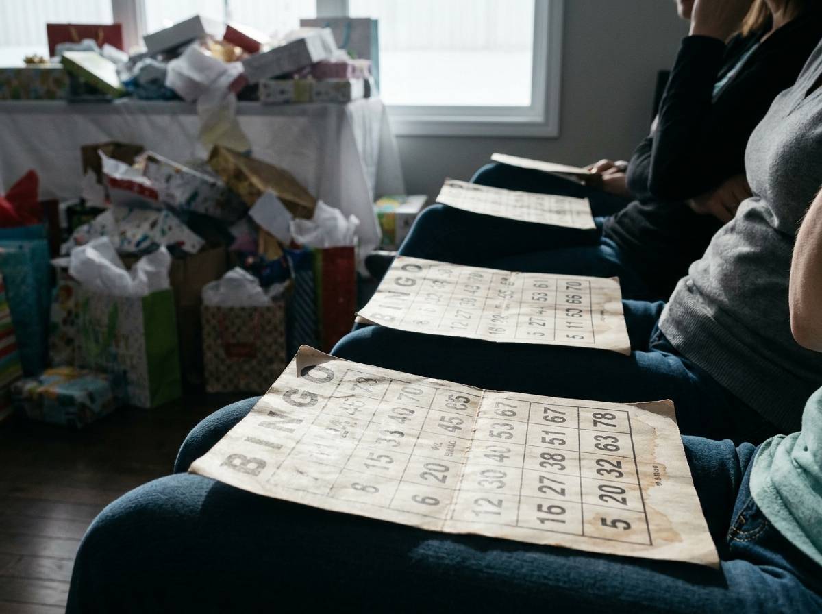 Karty do Baby Bingo trzymane przez gości podczas rozpakowywania prezentów