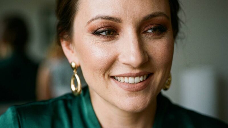 Kobieta w intensywnym makijażu smokey eye na wesele, elegancka sukienka koktajlowa