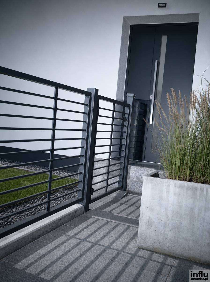 Ażurowe metalowe ogrodzenie prowadzące do nowoczesnego wejścia do domu