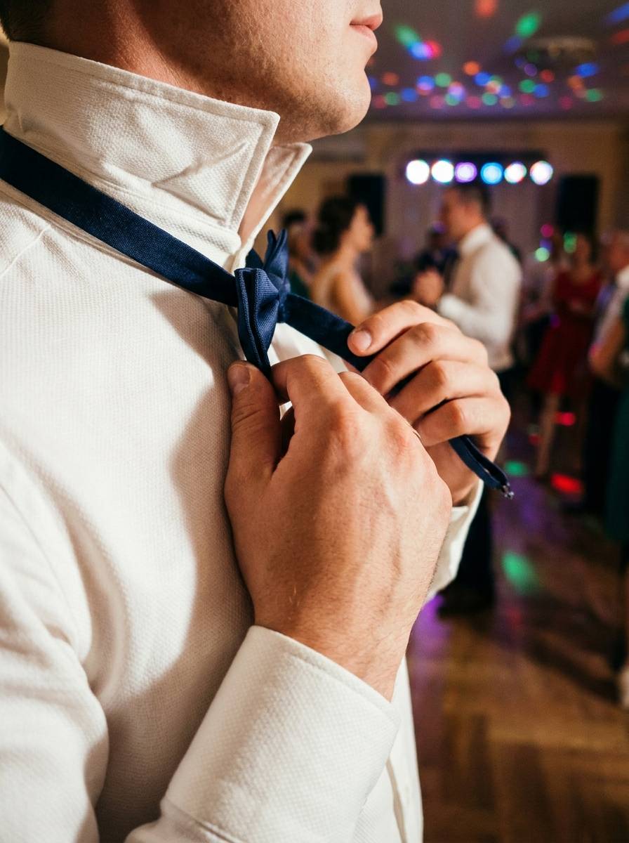 Pan młody odpina muchę podczas tradycyjnych oczepin weselnych