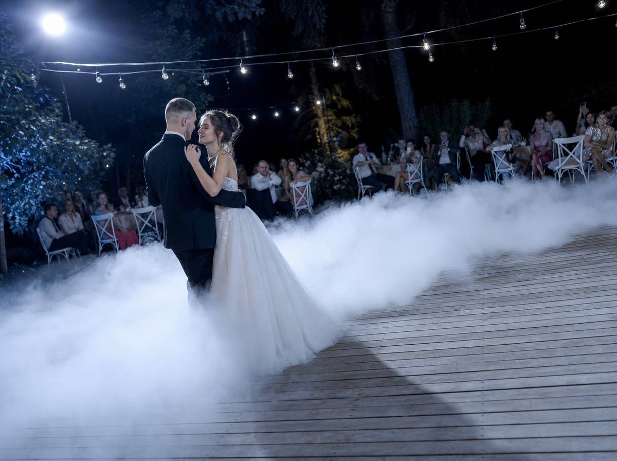 Pierwszy taniec pary młodej w gęstym dymie na weselu w plenerze