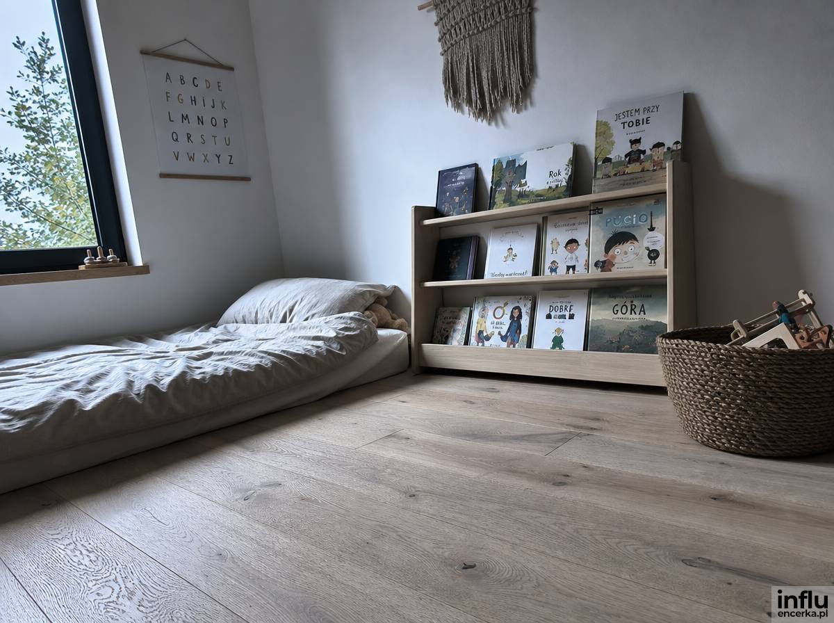 Pokój Montessori z materacem podłogowym i niską półką na książki