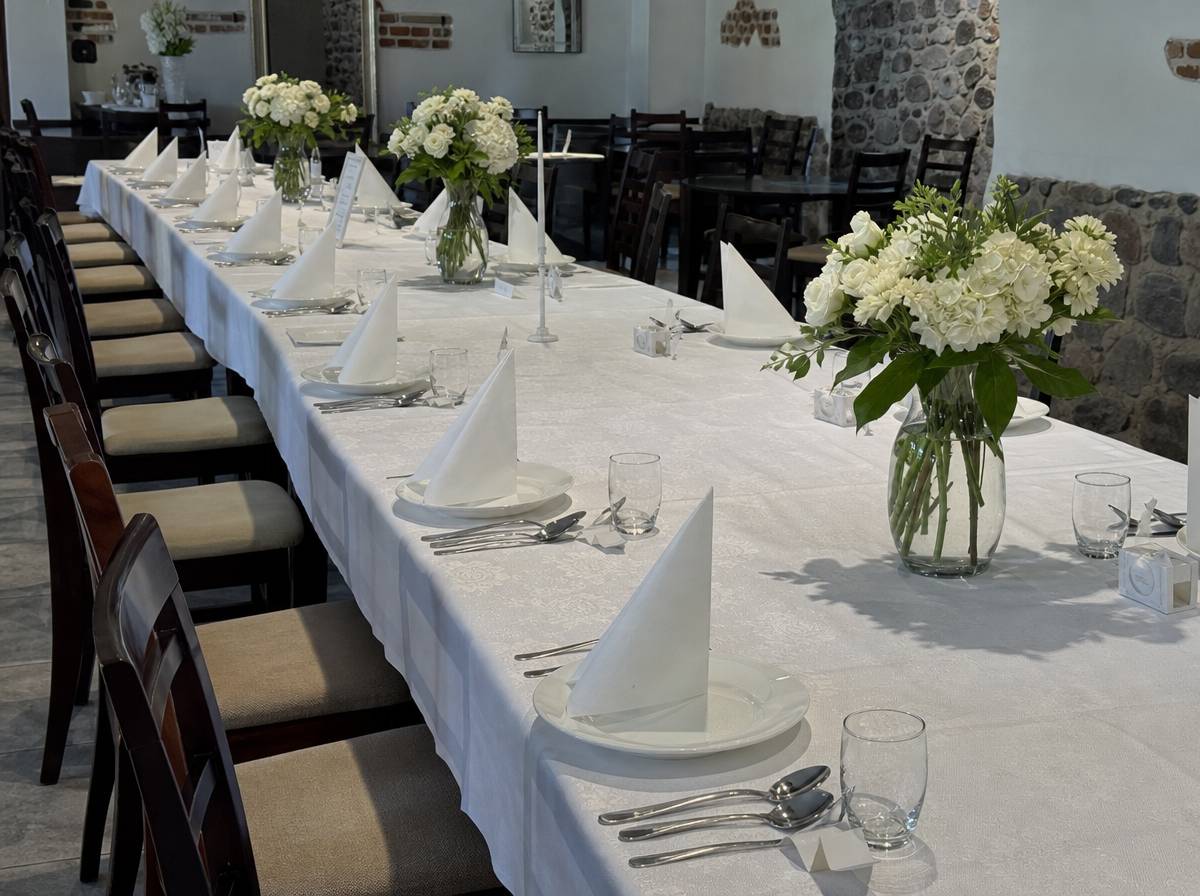 Nakryty stół w sali restauracyjnej przygotowany na chrzciny